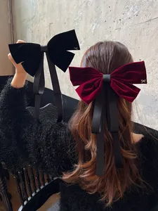 Detail of elegant velvet bow hair clip with long ribbons on hair for styling