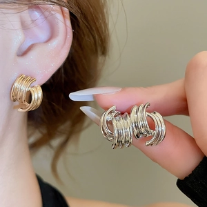 Detailed close-up of multi-layer spiral C-shaped silver earrings with high-gloss finish