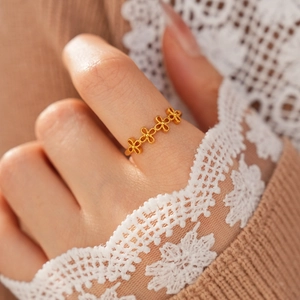 Gros plan d'une bague vintage plaquée or avec motif trèfle ajouré portée par un mannequin