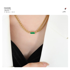 Detail of gold double-layer chain necklace featuring a rectangular emerald zircon stone