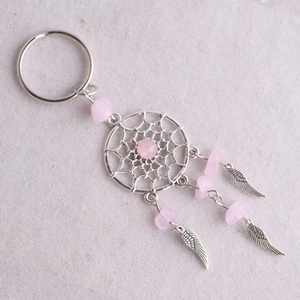 Detalle del llavero atrapasueños con piedras de cristal rosa y colgantes de alas