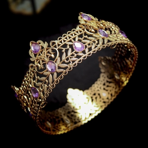 Detailed view of luxury baroque golden crown with purple teardrop crystals and gold filigree