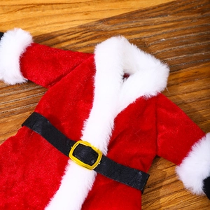 Close-up of red velvet Christmas wine bottle cover with faux fur and black belt detail