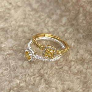 925 silver twist ring with yellow cushion cut stone and diamond halo on plush background