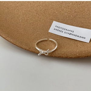 Detail of S925 sterling silver bow ring featuring an adjustable open band and stamp