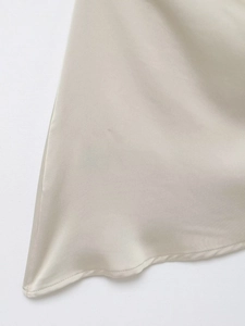 Détail du tissu en satin champagne avec texture lisse et couture d'ourlet délicate