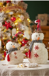 Dettaglio di pupazzi di neve in peluche con cappelli scozzesi in un caldo set natalizio