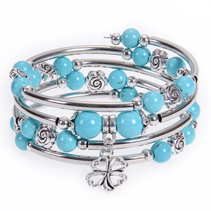 Detail of bohemian wrap bracelet featuring turquoise beads and clover lucky charm