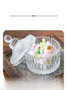 Detail display of a vertical ribbed glass candy jar with dome lid on a dark wooden tray