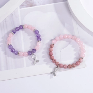 Détail de bracelets en cristal rose et rhodochrosite avec charms rubans de sensibilisation