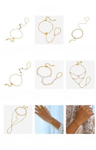 Makroansicht von Fingerarmbändern aus goldfarbenem Titanstahl mit Perlen und Schmetterlingen