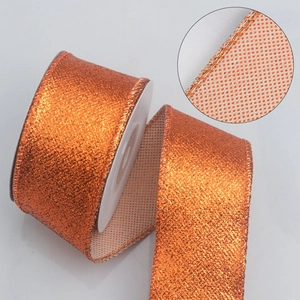 Orange glittering Christmas ribbon with reinforced stitched edges on a white spool roll