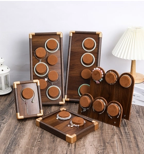 Detail of walnut wood jewelry display set with brown velvet pillars and gold corner accents