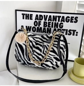 Detail showing plush zebra pattern faux fur texture with gold chain and PU strap