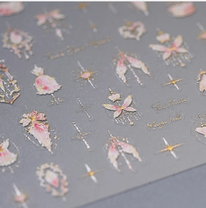 Macro shot of gold foil nail stickers with butterflies, crowns, and Lolita dress patterns