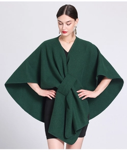 Detailed knit of dark green poncho wrap featuring a stylish large front bow design