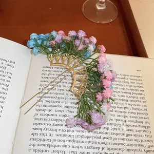 Détail d'une fourche à cheveux dorée avec fleurs colorées sur un livre de style rétro