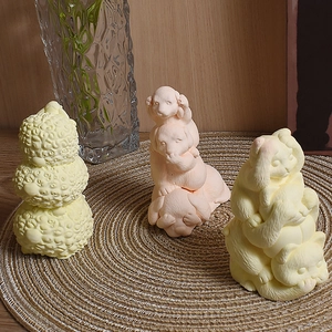 Close-up of stacked animal candle molds featuring cute sheep, dog, and cat designs