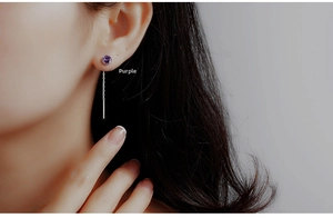 Close-up of S925 sterling silver drop earrings with purple zircon tassels on a model