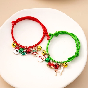 Detail of adjustable Christmas braided bracelets with enamel charms in red and green