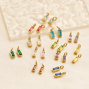 Macro detail of rectangle multicolor birthstone charms with gold plated borders for DIY jewelry