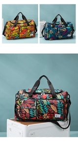 Detail of printed travel tote bag with vibrant leaf patterns and multiple zip pockets