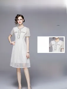 Detail view of French-style white lace midi dress featuring intricate floral embroidery