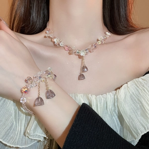 Detailed shot of pink crystal necklace with white resin flowers and purple pendant