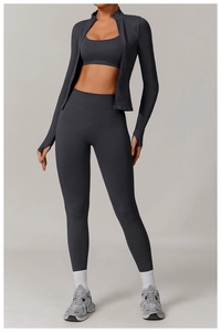 Three-piece dark gray seamless yoga set with slim fit zip jacket, bra, and high-waist leggings