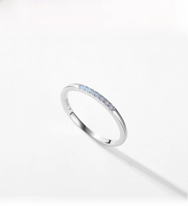 Macro shot of S925 sterling silver ring with inlaid light blue round gemstones