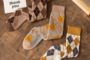 Detailed knit texture of argyle pattern knee-high socks in three classic colors