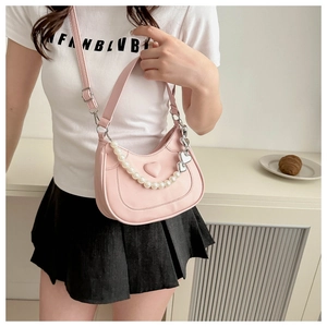 Detail view of pink half-moon saddle bag with pearl chain and heart embossing decoration