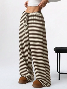 Detail of high-waist striped wide-leg pants featuring an elastic drawstring waistband