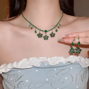 Detail of green zircon flower and teardrop tassel necklace and earrings set worn on model