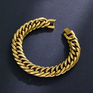 Dettaglio del bracciale a catena cubana dorata con chiusura quadrata su sfondo grigio