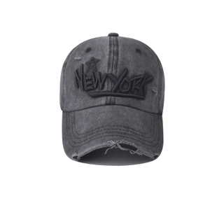 Detailed close-up of distressed cotton New York embroidery on washed grey baseball cap