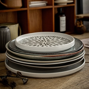 Stack of colorful ceramic steak plates with radial patterns on a wooden table