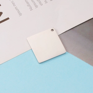 Polished square stainless steel pendant with hole on a minimalist background