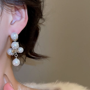 Primo piano di eleganti orecchini di perle argentati indossati da una modella per un look chic