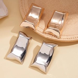Flat lay of four pairs of irregular rectangular metallic earrings in gold and silver finish