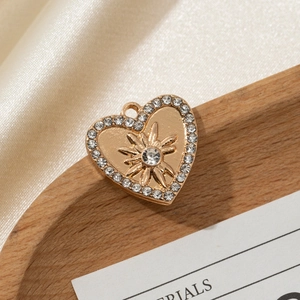 Macro detail of heart-shaped gold pendant with star pattern and white rhinestones