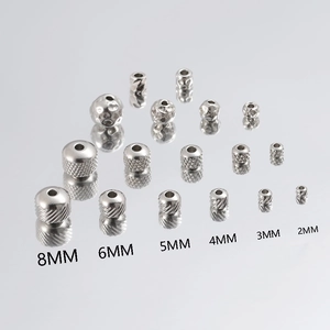 Polished stainless steel beads in various sizes and textures on a reflective mirror base