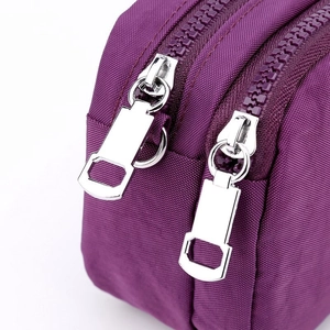 Women's purple nylon crossbody clutch with dual silver zippers and multi-compartment design