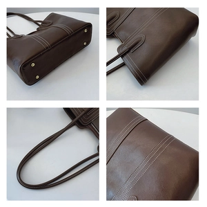 Detail of dark brown leather tote with white stitching and protective metal feet