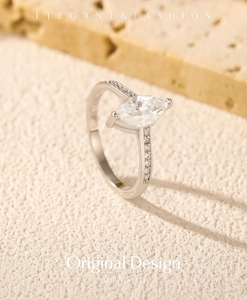 Macro shot of silver marquise-cut moissanite ring with diamond accents on stone base