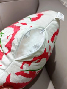 Close-up of the hidden zipper closure and white cotton filling on leaf print pillow