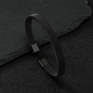 Black mesh textured titanium steel cuff bracelet with smooth end caps on dark slate