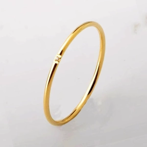 Detail shot of a minimalist 18K gold plated titanium ring with a small square diamond inlay
