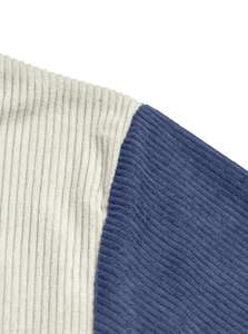 Macro shot of corduroy fabric texture showing beige body and navy blue sleeve seams