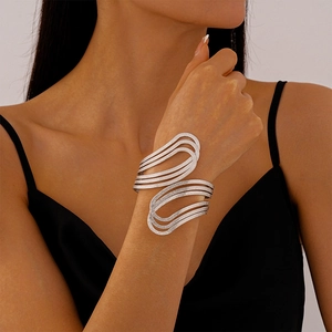 Detail of layered silver geometric cuff bracelet with shimmering frosted finish texture